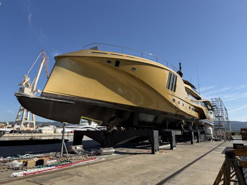 Yacht supported in a dry dock for shaft alignment and maintenance inspection.